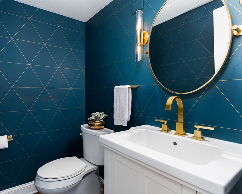 deep blue wallpapered bathroom with gold accents