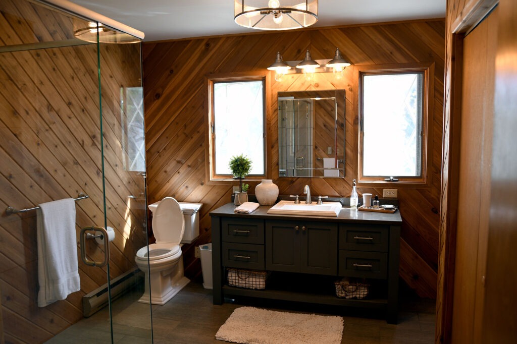 cozy master bathroom with wooden walls and dark tone accentss