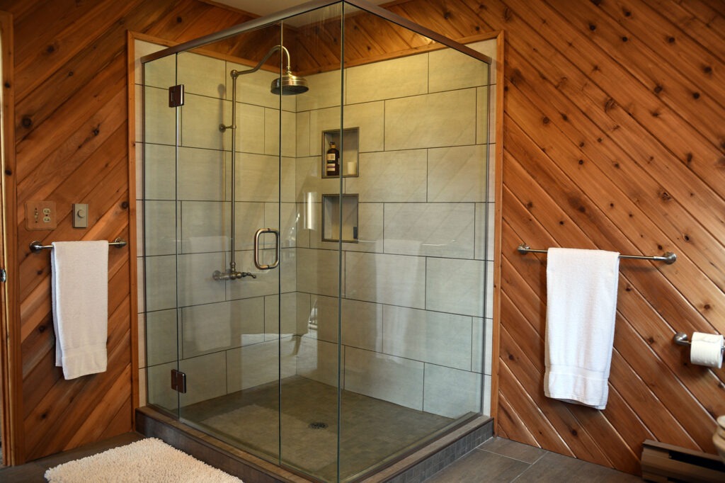 tiled shower with wooden paneled walls